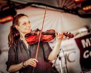 Rachel Schott on a festival stage with a violin